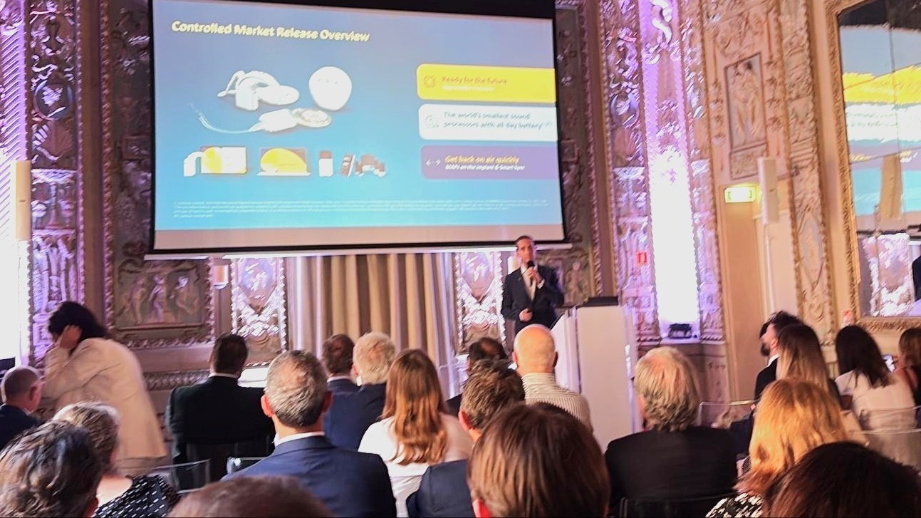 Tiago R. Felix on stage, giving a presentation to an audience.