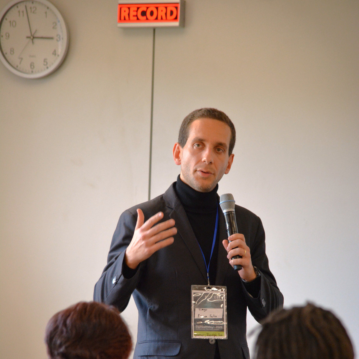 Tiago R. Felix speaking on a microphone in front of people.